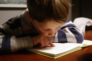 What Are Evidence-Based Dyslexia Programs and Why Do They Work 2 boy in gray and red hoodie reading book
