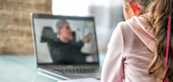 woman in pink long sleeve shirt sitting in front of macbook pro