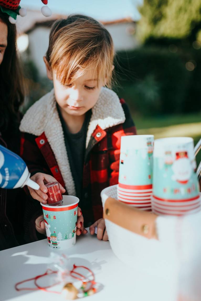 Kids Christmas Craft Morning 1 girl in red and white jacket holding blue and white ceramic mug