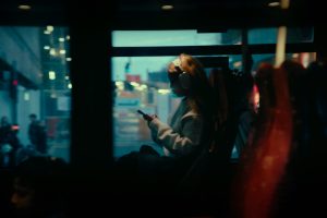 When to Activate a Digital Travel eSIM Before Going Overseas 11 Woman on a bus looking at her phone
